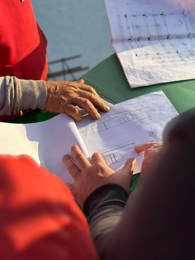 Profissionais revisando desenhos técnicos em campo